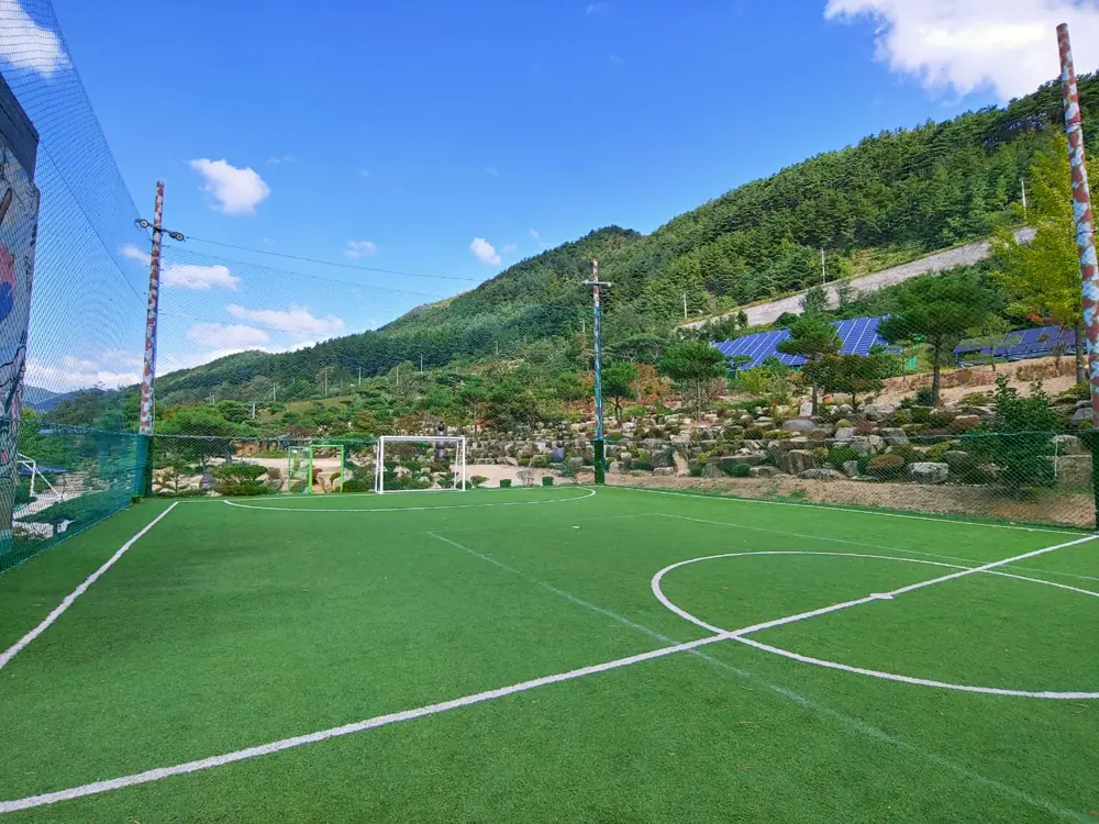 산으로 둘러싸인 잔디 운동장